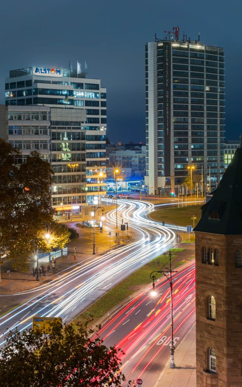 Long-exposure night view of car light trails at Ernst-Reuter-Platz, Berlin, with office towers